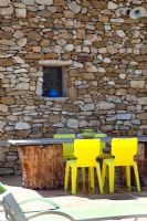 Garden table and chairs by rustic stone wall