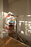 Large pile of books on modern chair 