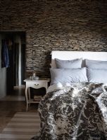 Modern country bedroom with dry stone wall
