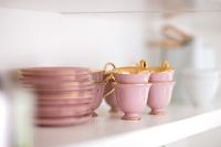 Pink and gold crockery set on shelf, detail
