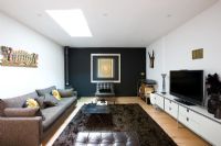 Contemporary living room with black feature wall and brown rug