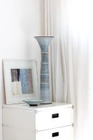 Grey pottery candlestick on white bedside cabinet