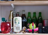 Wooden open shelves with cosmetics and drinks bottles