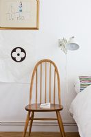 Vintage wooden armchair next to bed