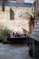 Walled garden with vintage table and built in benches