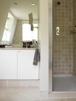 Shower cubicle and vanity unit in alcove with large mirror