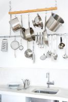 Steel cooking utensils on meat hooks 