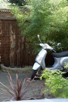 Silver scooter in courtyard garden