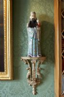 Oriental figure on ornate shelf