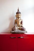 Buddha statue on red cabinet