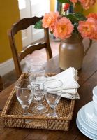 Country dining table with glassware on wicker tray