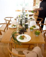 Table set for dinner with man pouring wine
