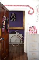 Door to colourful hallway with bicycle
