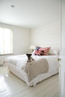 Country bedroom with Jack Russell on bed