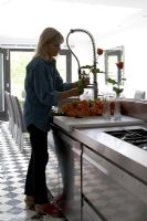 Woman arranging flowers in contemporary kitchen