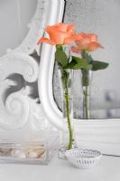 Single rose in vase by distressed mirror 