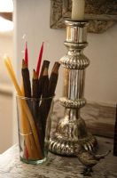Silver candle stick and pencils in glass