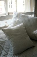 White and gold cushions on bed