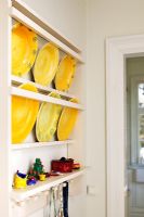 Collection of yellow plates on wall rack