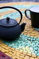 Black teapot and cup on table