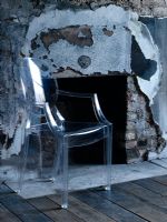 Perspex chair next to fireplace