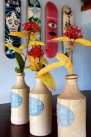 Tropical flowers in earthenware bottles