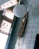 Detail of jewellery on hook in bathroom 
