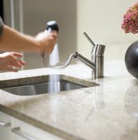 Woman using spray attachment on kitchen sink