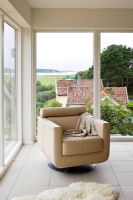 Contemporary armchair next to large windows