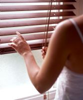 Woman pulling down blinds