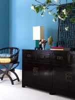 Dark wood oriental style sideboard against blue wall