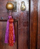 Dark wood door with tassels hanging from handle