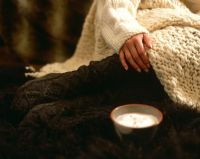 Woman wearing cosy woolen clothes and slippers 