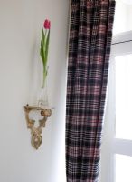 Tartan curtains and ornate shelf