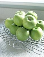 Modern metal fruit bowl full of apples 