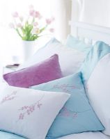 Patterned pastel cushions on bed 