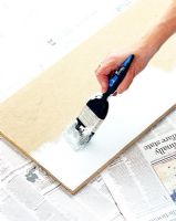Person painting wooden shelf 