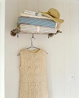 Shelf of fabrics and woolen dress on hanger 