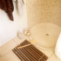 Detail of base of shower and wooden bath mat
