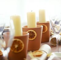 Detail of terracotta candle holders on table 