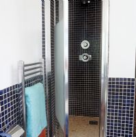 Shower cubicle in modern tiled bathroom 