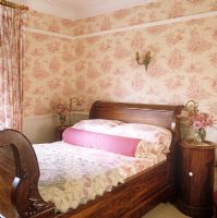 Country bedroom with floral wallpaper 