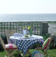 Table and chairs in coastal garden 