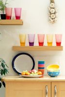 Colourful glassware on kitchen shelf 