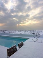 Garden furniture and swimming pool in snow 