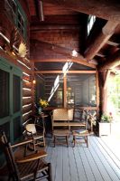 Garden furniture on porch of log cabin 