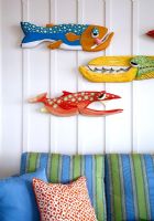 Colourful carved fish on living room wall 