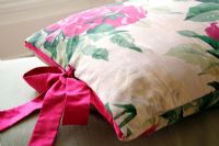 Detail of floral cushion with colourful bow 