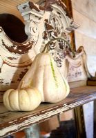 Two pumpkins on distressed mantelpiece 