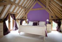 Country bedroom with purple feature wall 